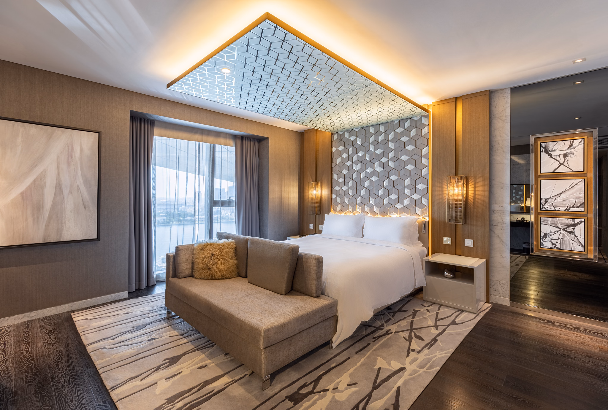 King bed beneath a geometric feature wall at Al Bandar Rotana in Dubai Creek, UAE