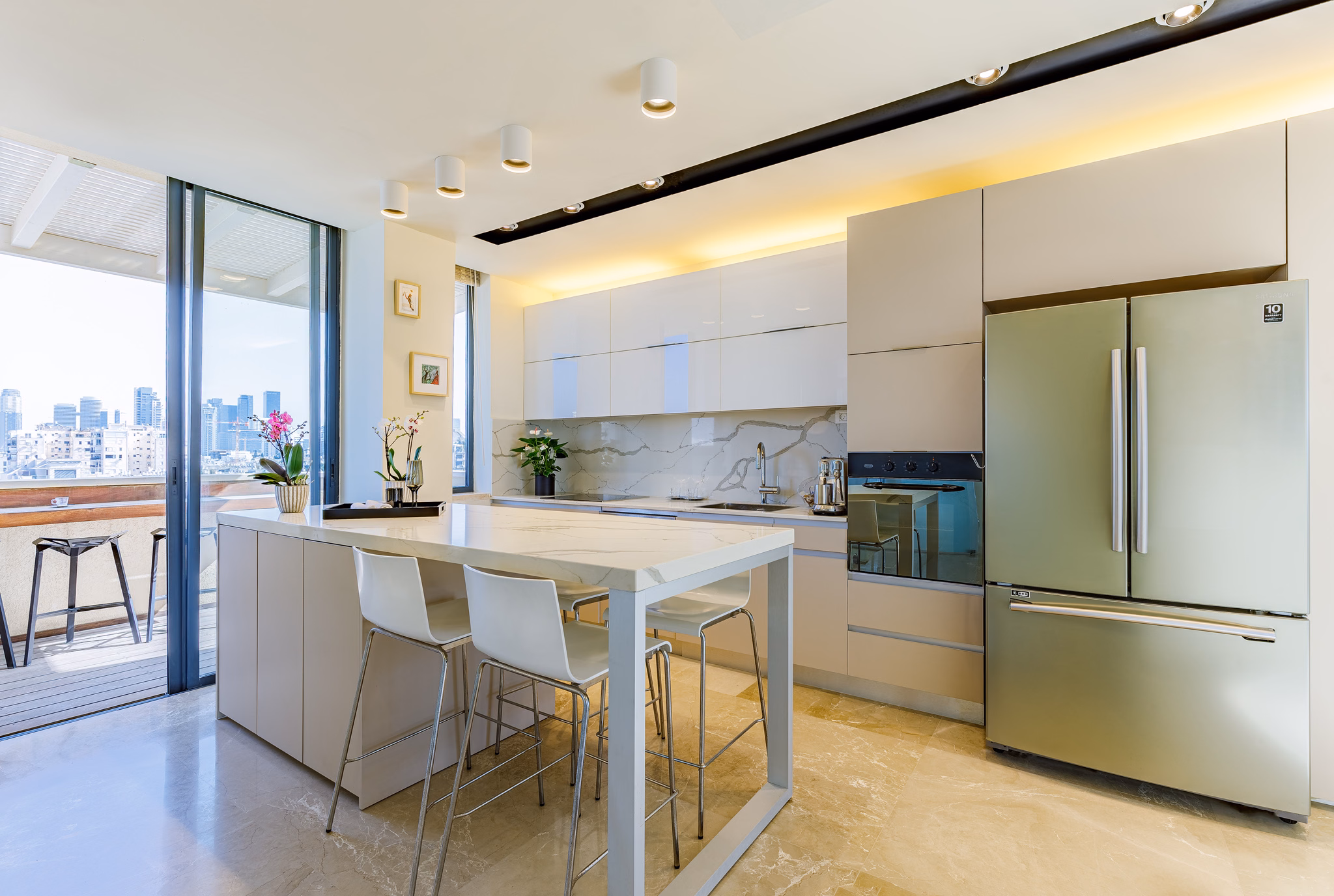 White kitchen and marble-topped island at Dizengoff Duplex in Tel Aviv, Israel
