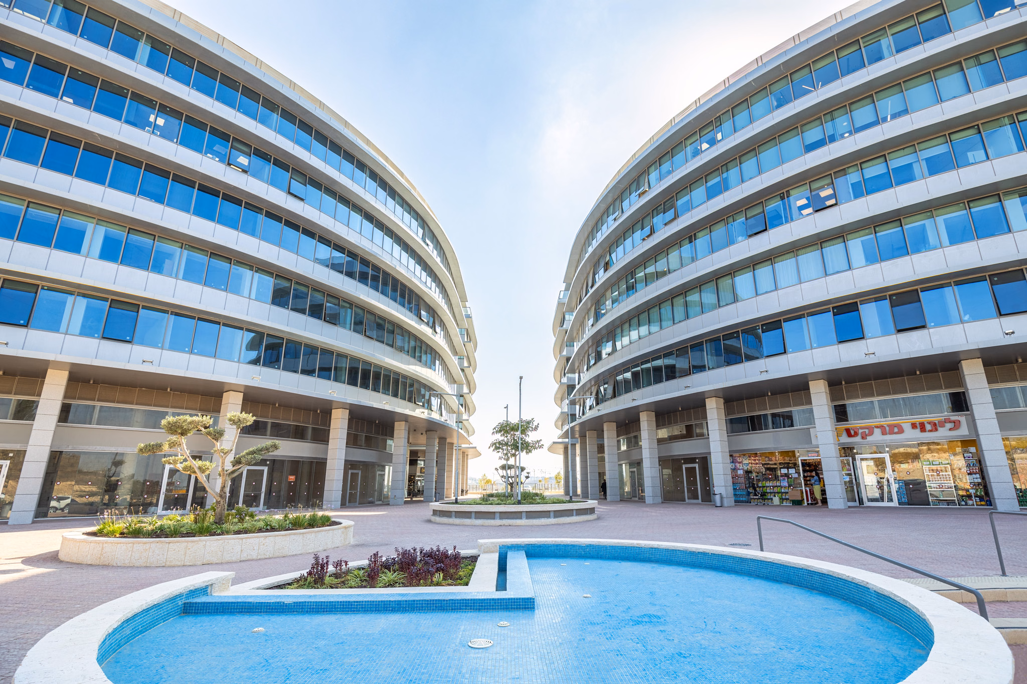 Courtyard fountain between curved buildings at Platinum Four in Modi'in, Israel