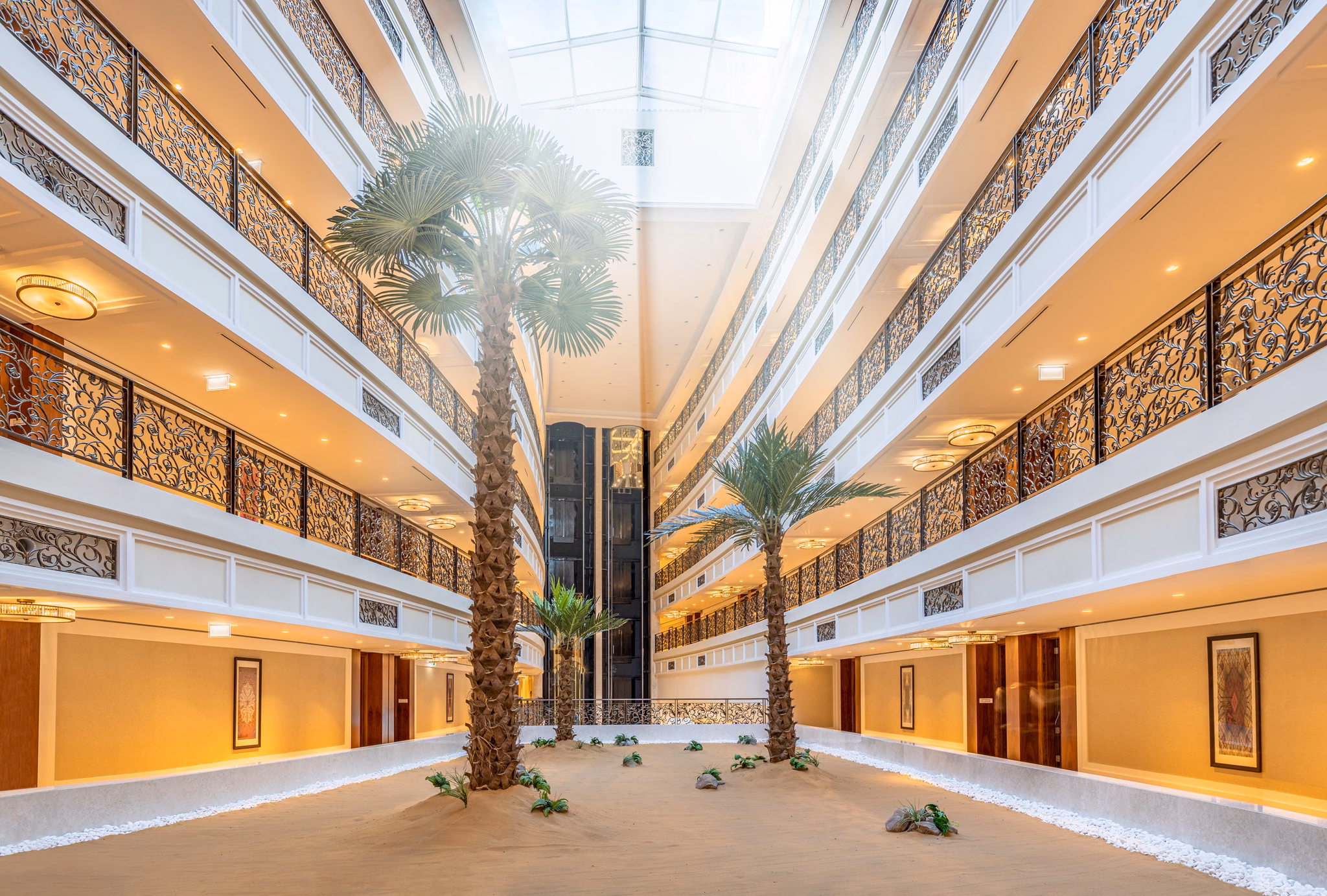 Multi-storey hotel atrium with palm trees at Waldorf Astoria Dubai Palm Jumeirah in Dubai, UAE