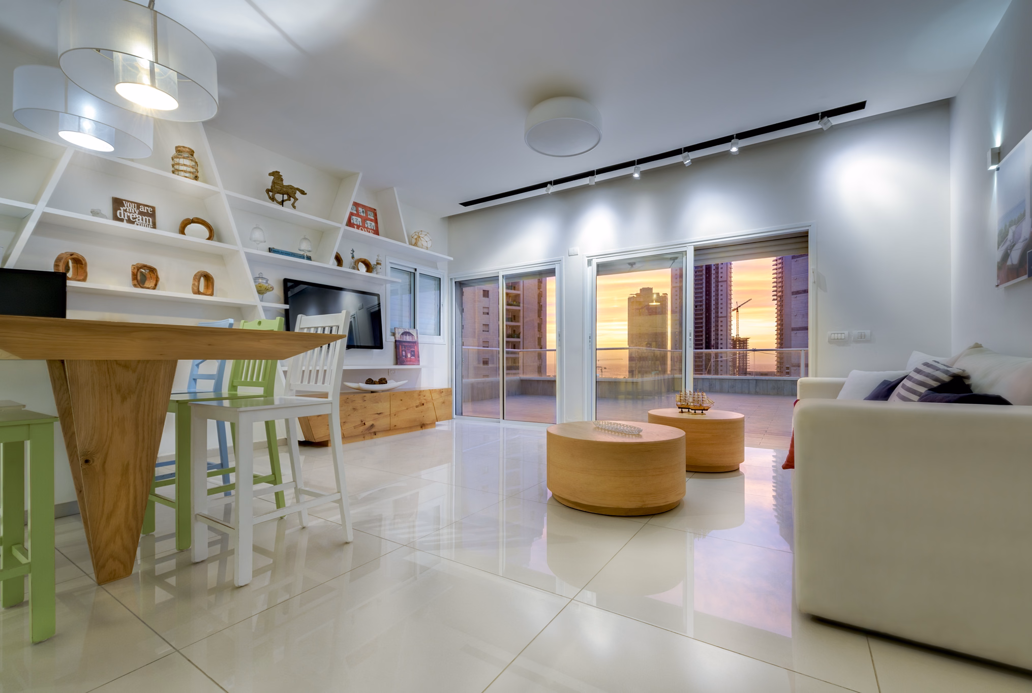 Open penthouse living and dining room in Bat Yam illuminated by warm sunset light