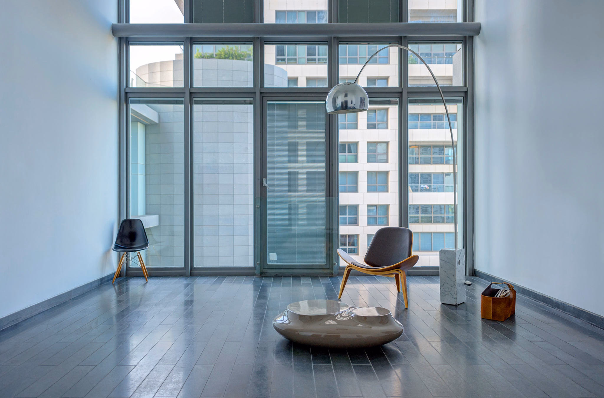 Minimal lounge with sculptural chairs and floor-to-ceiling windows at NAM Tower in Tel Aviv