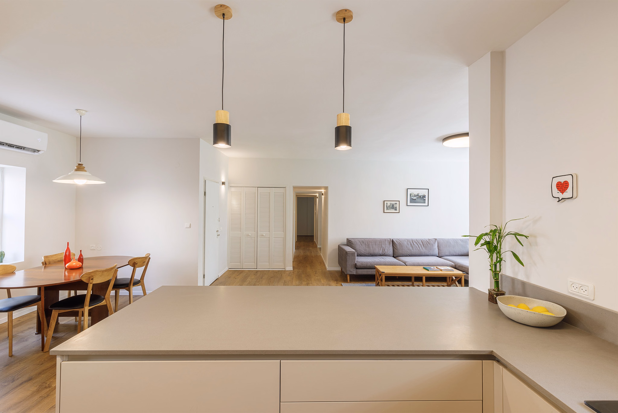 View across a modern kitchen counter toward the dining and living rooms in a Raanana apartment